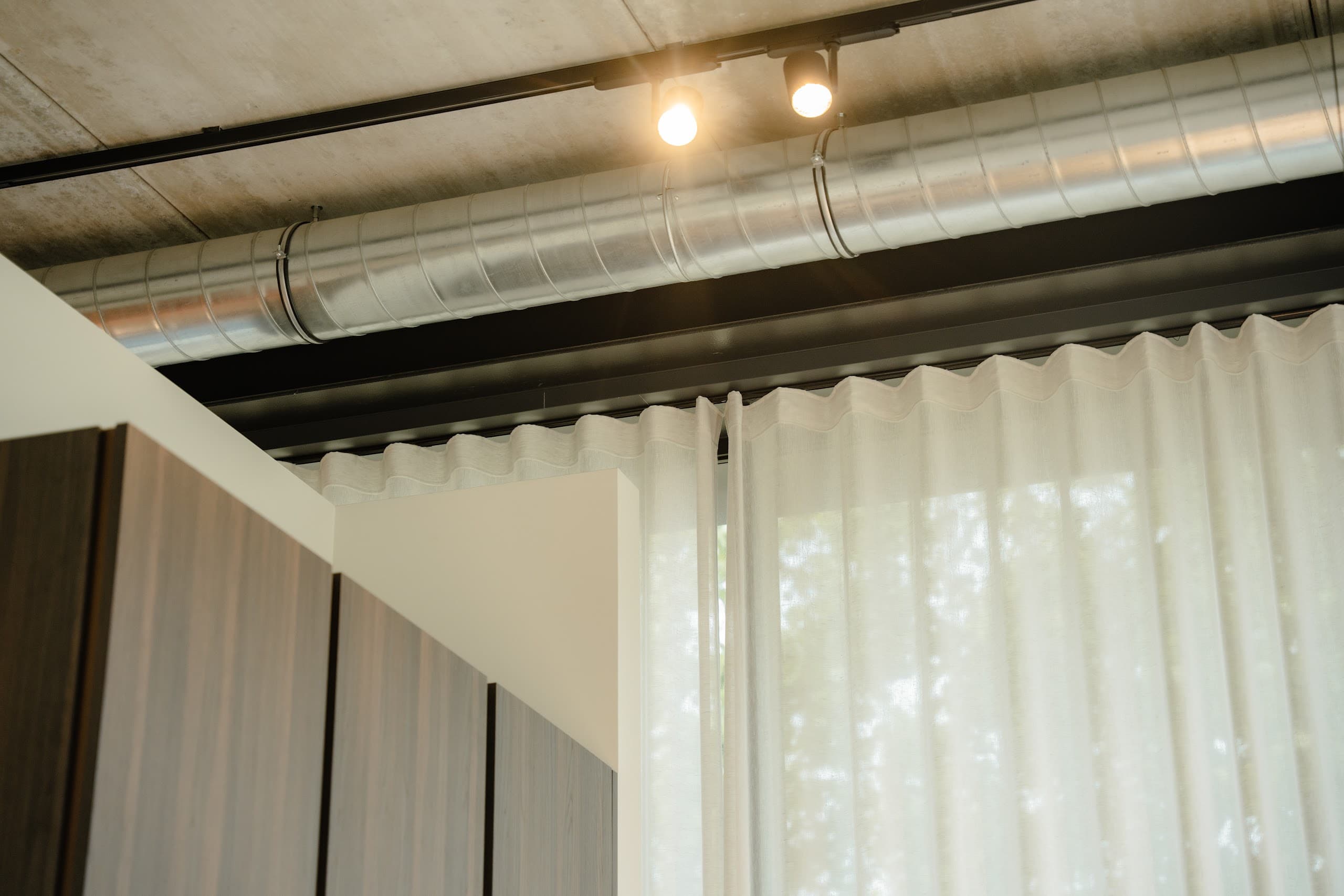 Showroom met zichtbaar plafond en gordijnen van plafond tot vloer