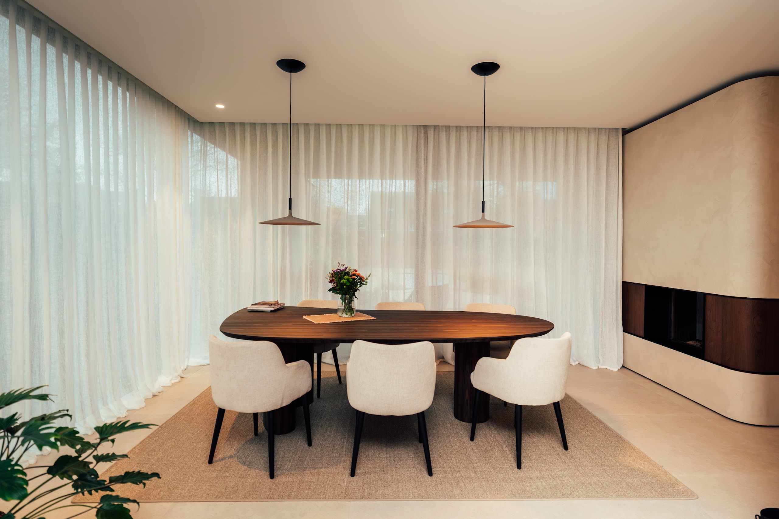 Eethoek met ronde tafel en transparante voiles langs de gevel
